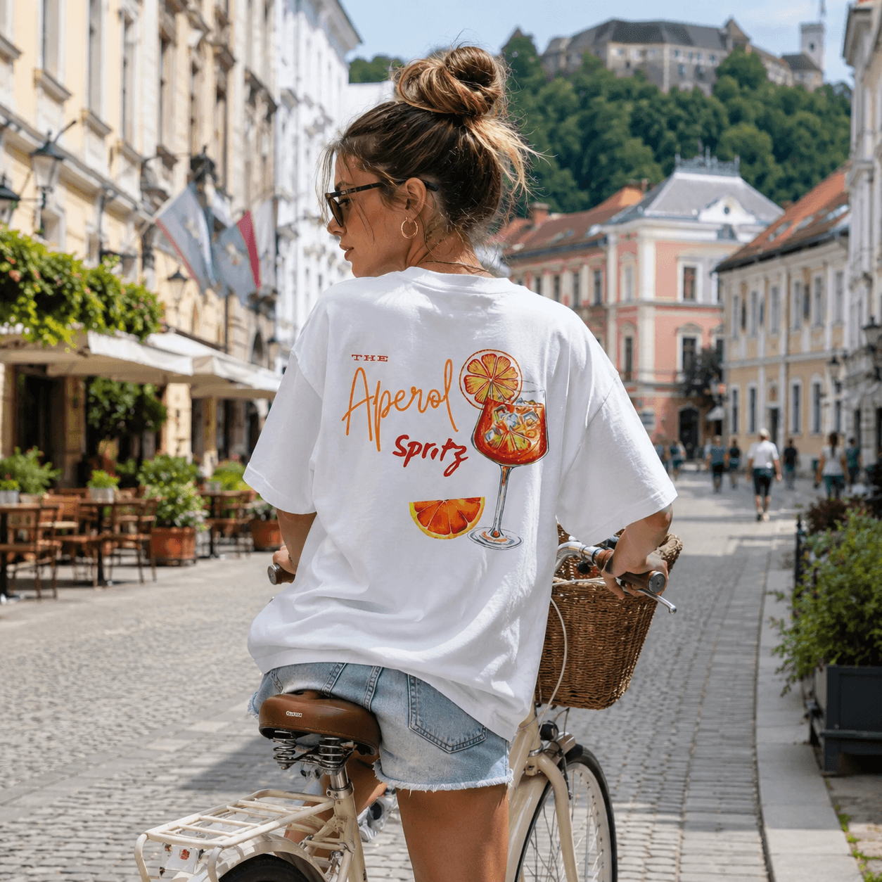 Ženska v beli ZENN majici Aperol Spritz na mestni ulici