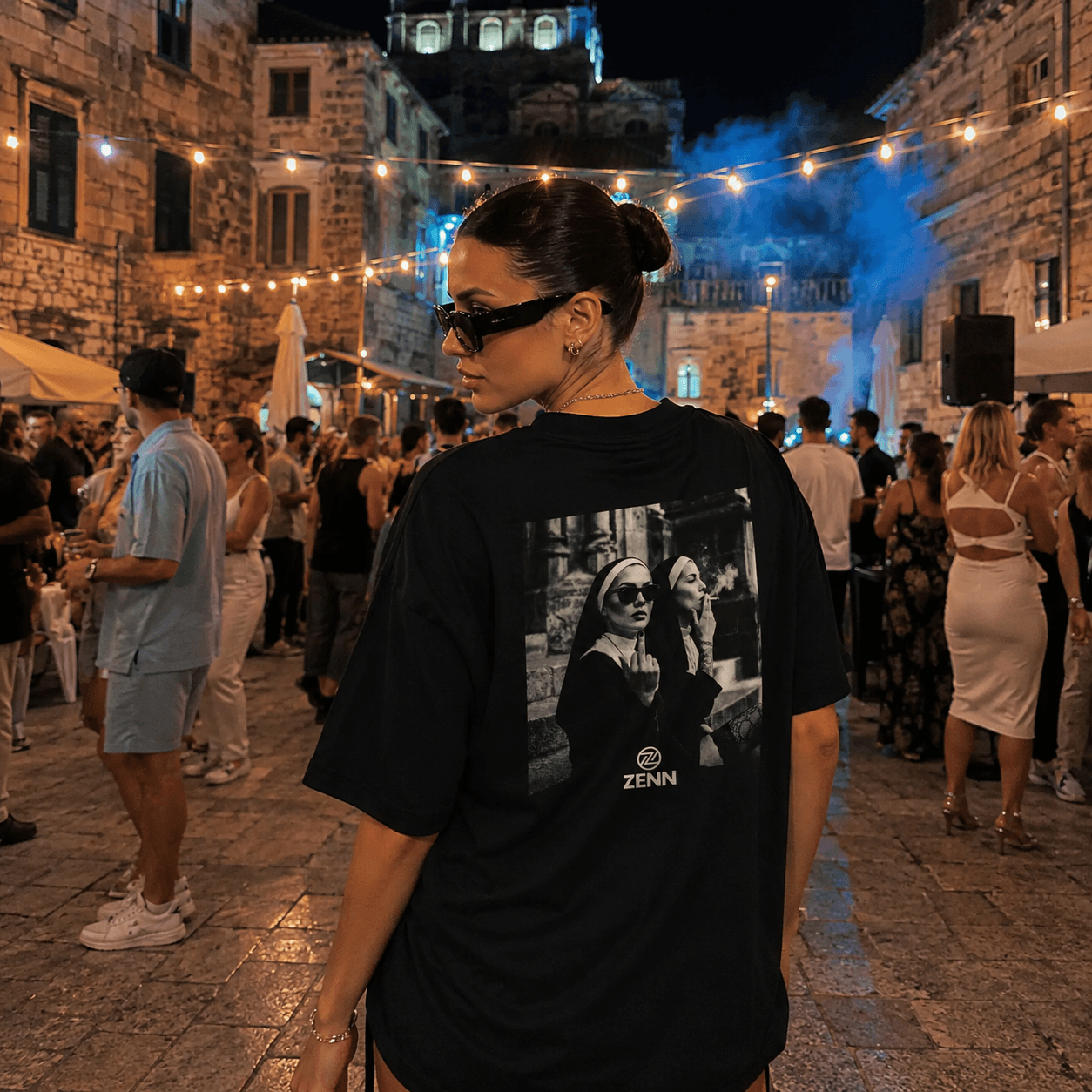 Ženska v črni ZENN majici z grafičnim potiskom na večernem dogodku